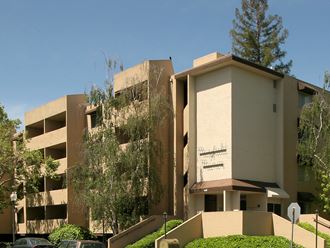 a large tan building with trees in front of it