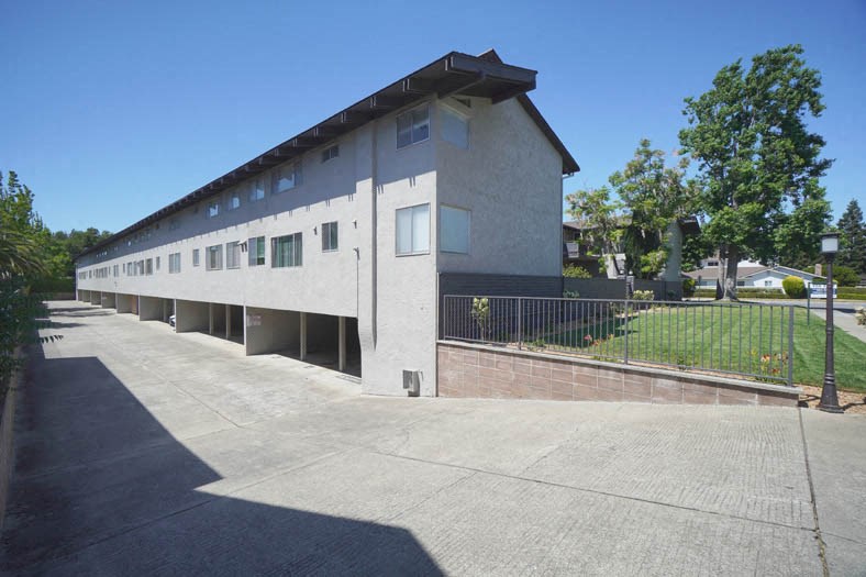 the side of a building with a street and a sidewalk
