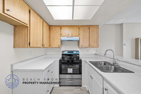 A kitchen with wooden cabinets and a stove top oven.