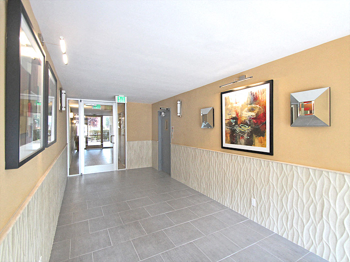 a hallway of a building with paintings on the wall