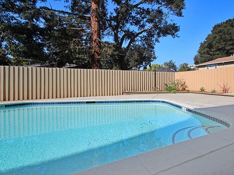 a swimming pool in a backyard with a fence