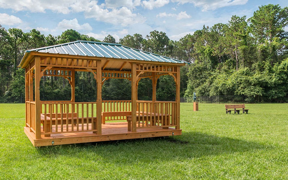 a gazebo in a field with a bench