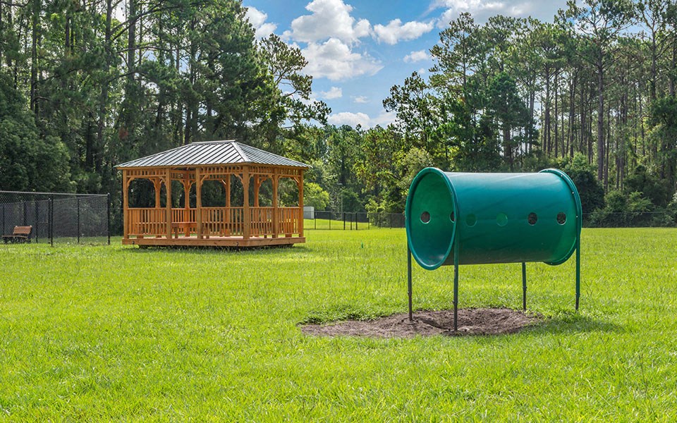 a park with a gazebo and a green telescope