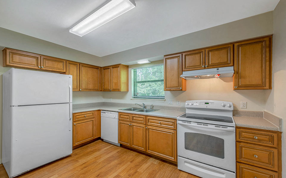 A kitchen with wooden cabinets and white appliances.