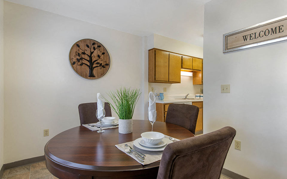 A dining room with a wooden table and chairs.