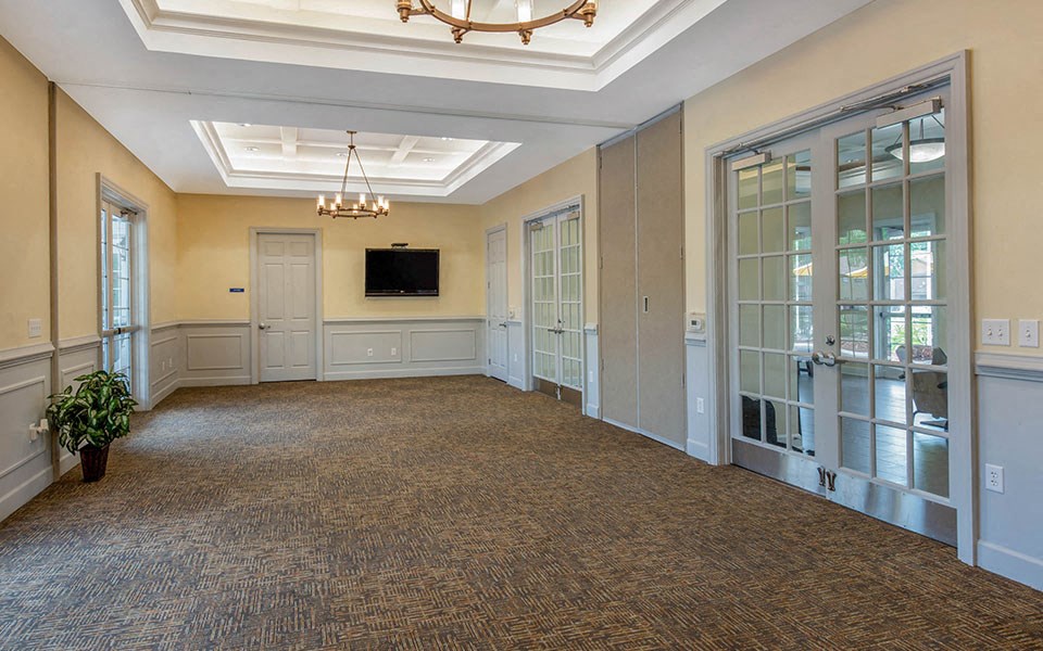 an empty room with glass doors and a tv