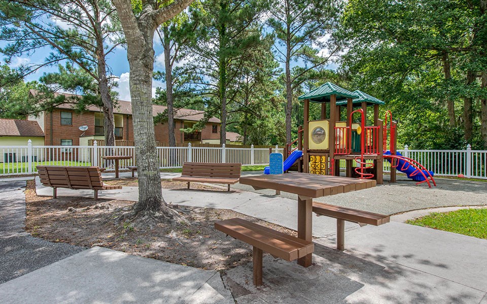 a playground with a picnic table and benches