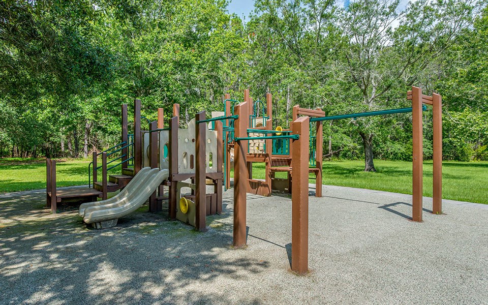 a playground with a slide and climbing equipment in a park