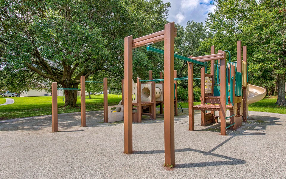 a playground with a swing set and a slide in a park