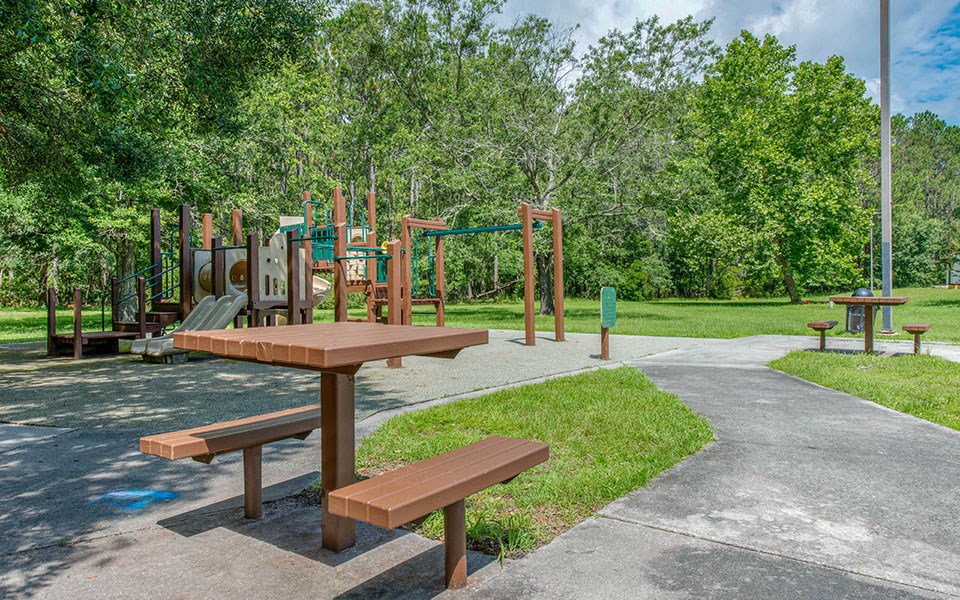 a picnic table and playground equipment in a park