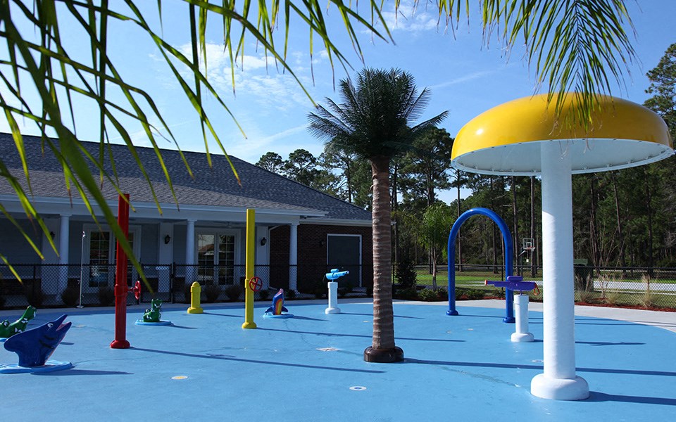 a playground with palm trees and other toys in front of a building
