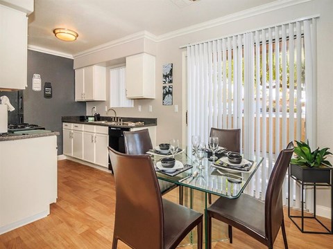 a kitchen and dining room with a glass table and chairs