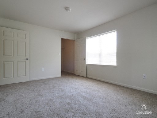 an empty living room with white walls and a window