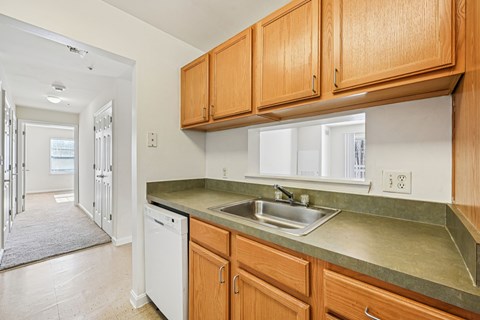 A kitchen with wooden cabinets and a white dishwasher.