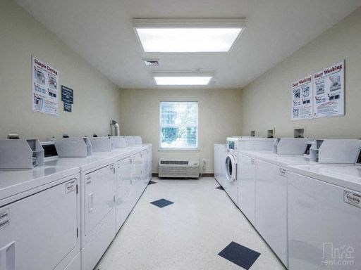 a large room filled with white washes and dryers
