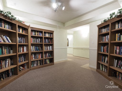 a room filled with shelves of books in a library