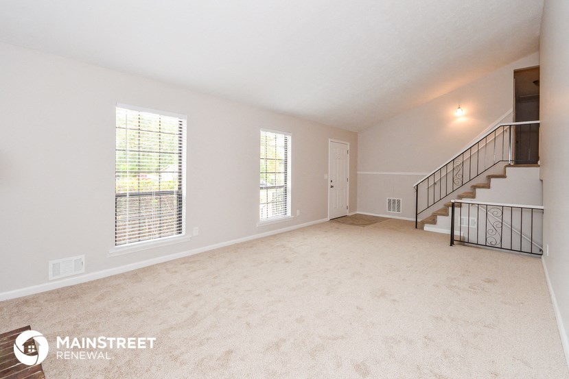 the spacious living room with stairs to the second floor