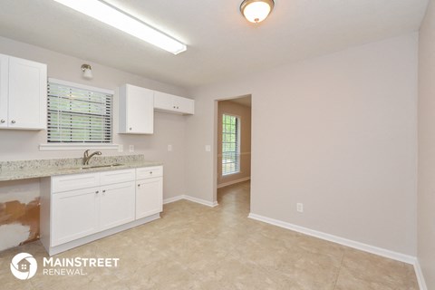 a kitchen with white cabinets and a counter top and a sink