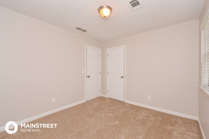 the upstairs bedroom has a carpeted floor and two closets
