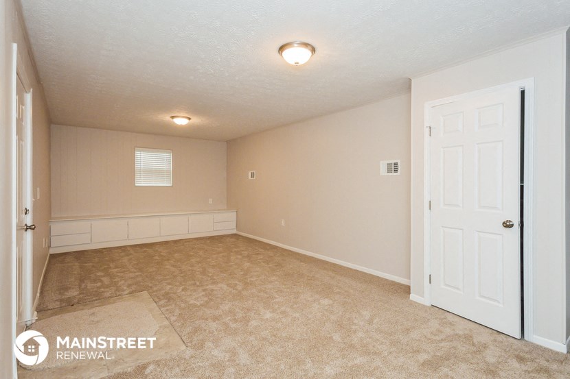 a bedroom with a white door and a carpeted floor