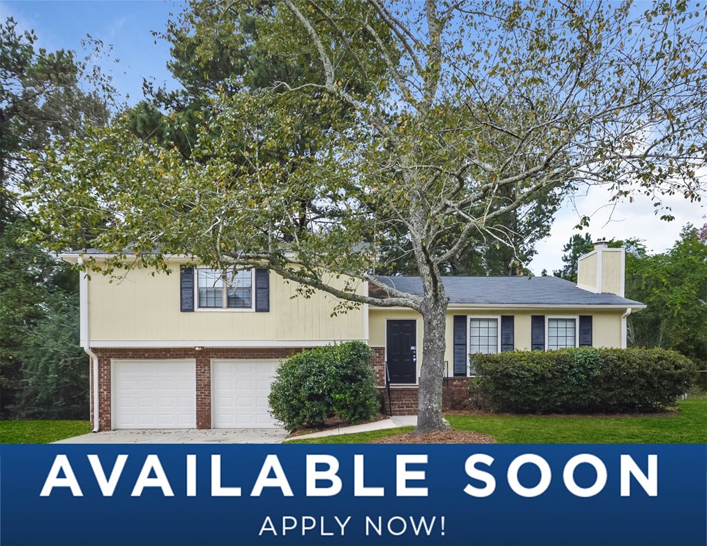 a yellow house with a tree in front of it