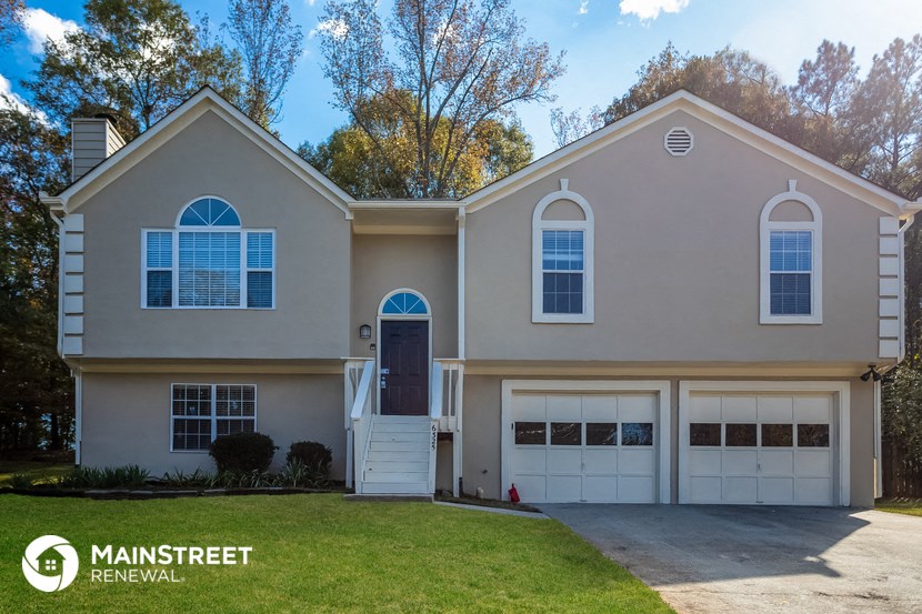 the exterior of a house with a driveway and a garage door