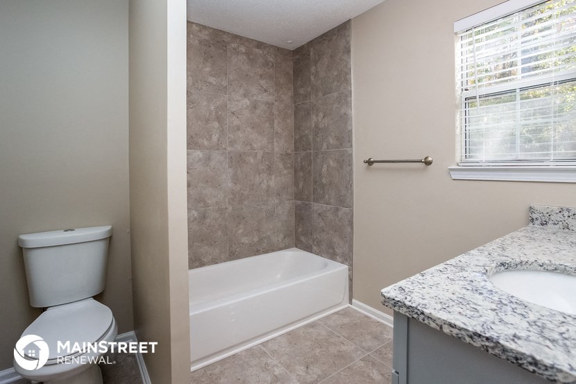 a bathroom with a toilet and a tub and a sink