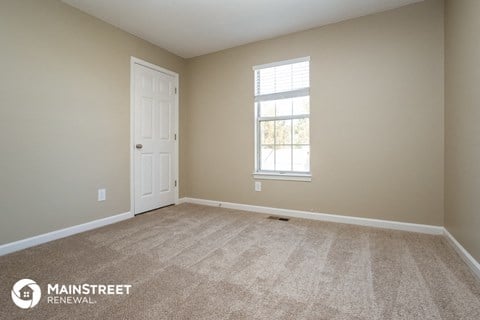 the living room of a home with carpet and a white door