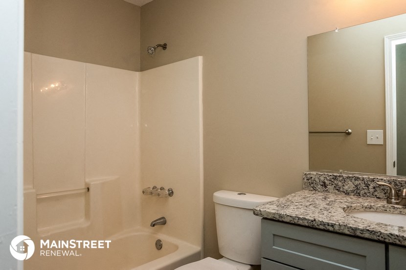 a bathroom with a toilet and a sink and a shower