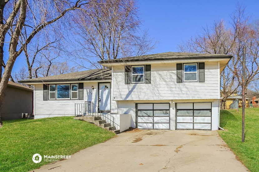 a white house with a driveway and a garage door