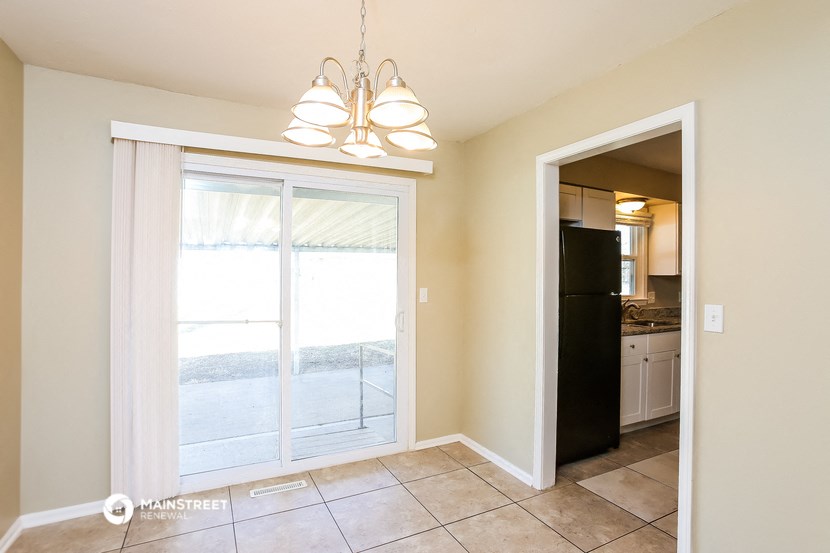 a dining room with a sliding glass door and a kitchen