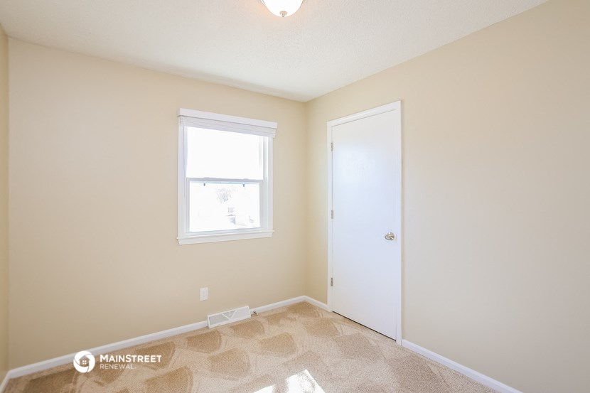 a bedroom with a white door and a window