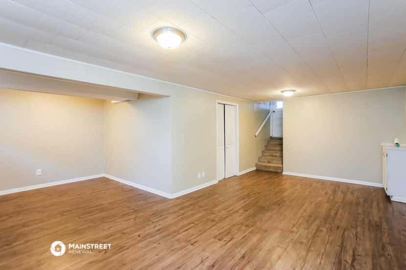 an empty living room with wood flooring and white walls