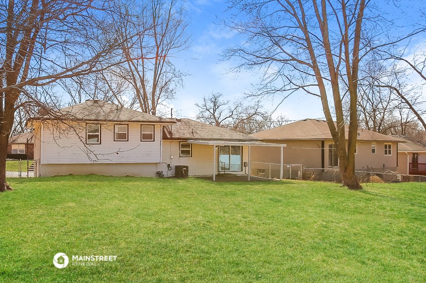 a white house with a yard and some trees