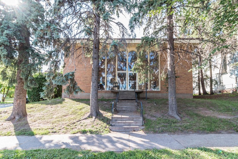 the front of a brick house with trees