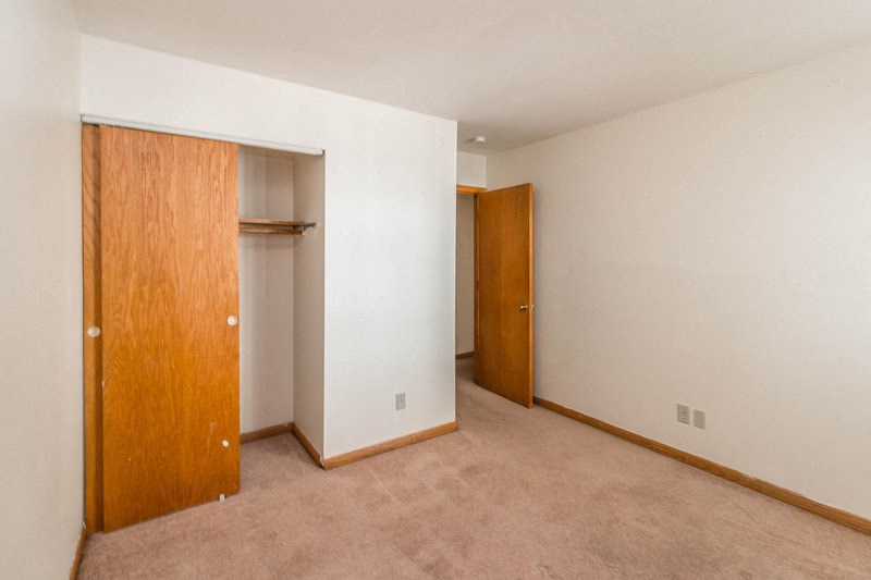 an empty room with a closet and a door