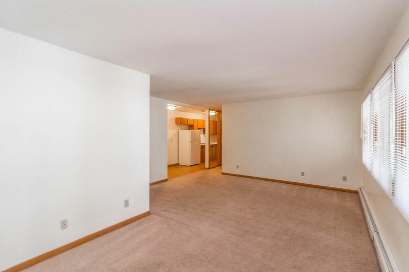 the living room and dining room of an empty house with a large window