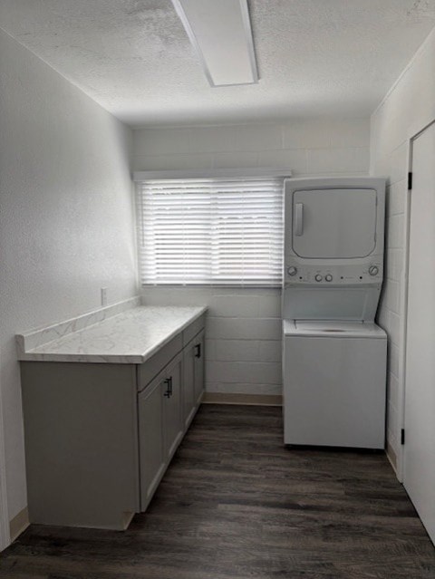 A small, white medical room with a cabinet and a monitor.