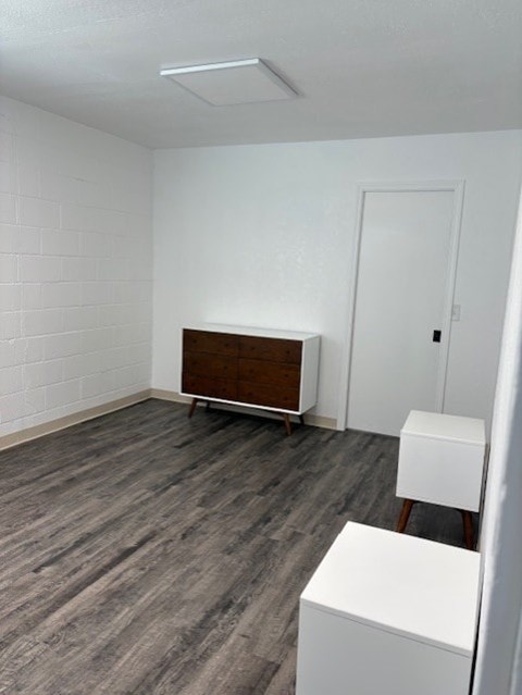 A room with a white wall and a wooden cabinet.