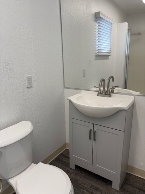 A white toilet sits next to a sink in a small bathroom.