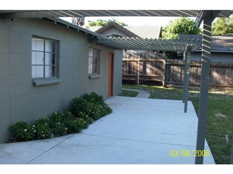 A house with a grey wall and a brown door.