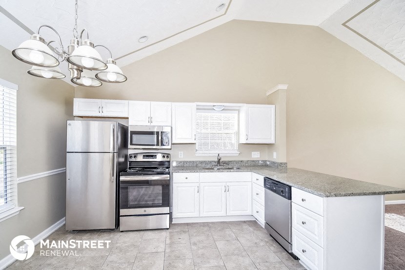 a kitchen with white cabinets and stainless steel appliances