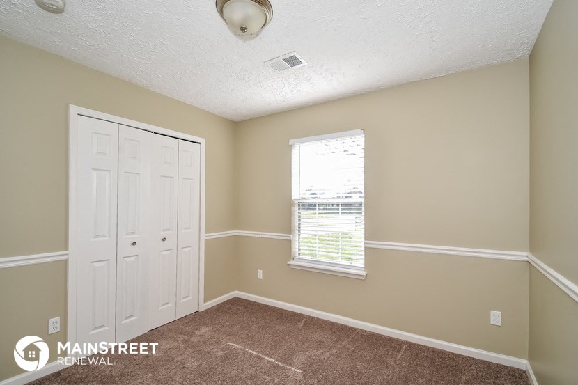 the master bedroom has a door to the closet and a window