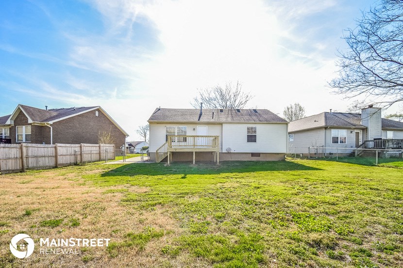 the backyard of a house with a yard and a fence