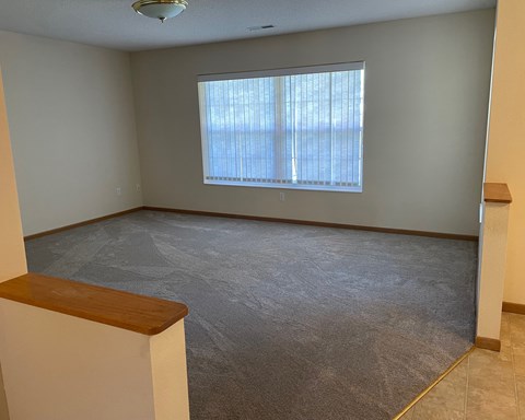 an empty living room with a large window