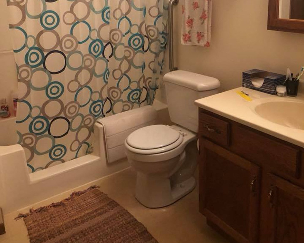 a bathroom with a toilet and a sink and a shower