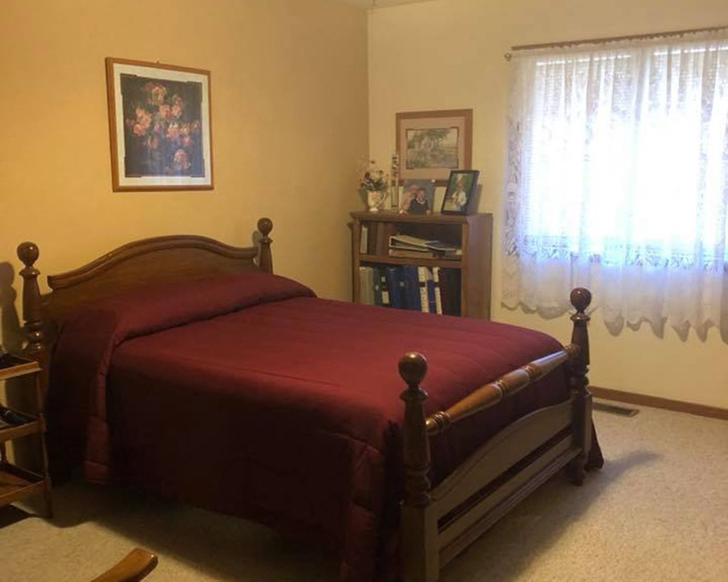 a bedroom with a bed with a red blanket on it