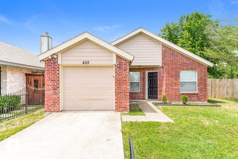 a small brick house with a white garage door