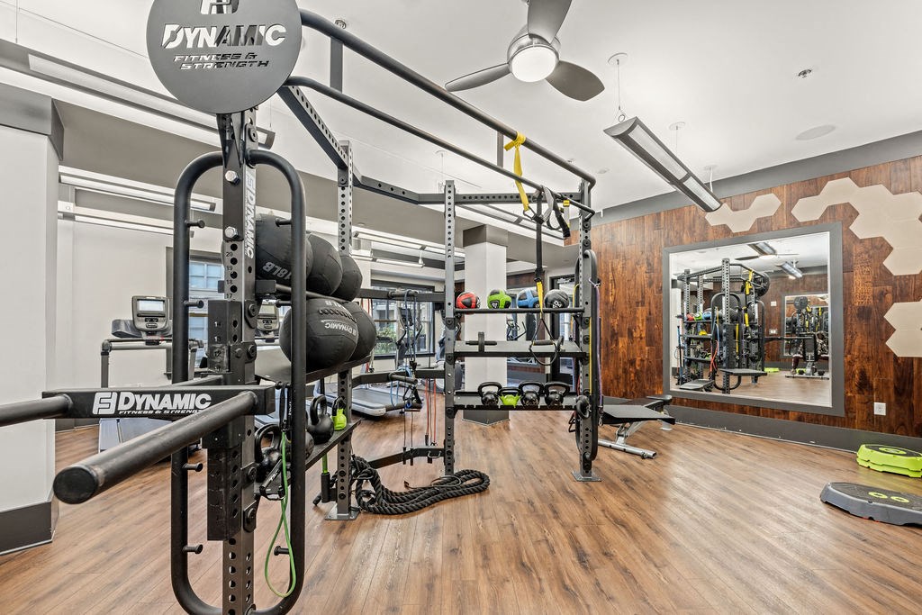 a home gym with weights and equipment on a wooden floor