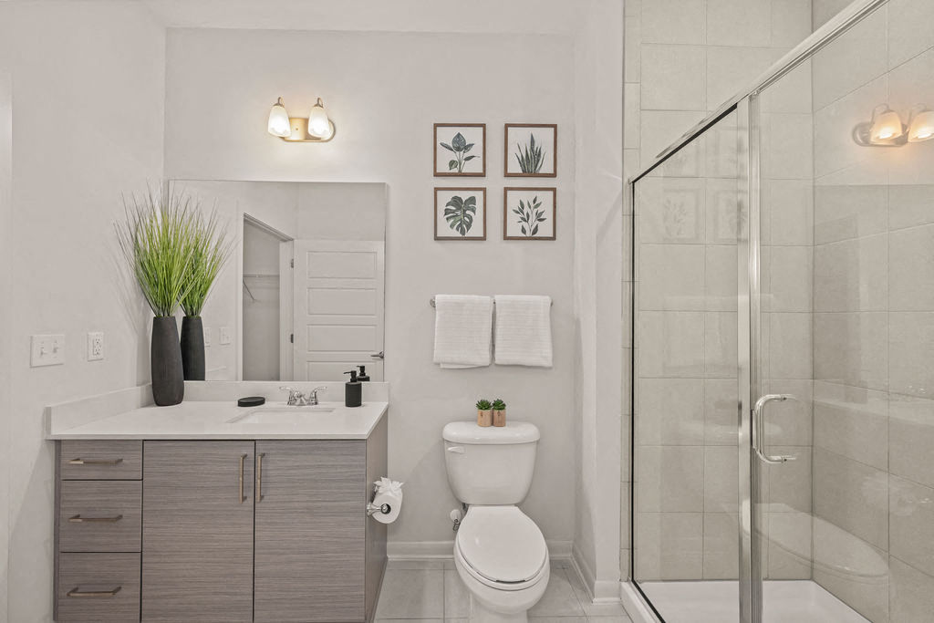 a white bathroom with a toilet and a shower